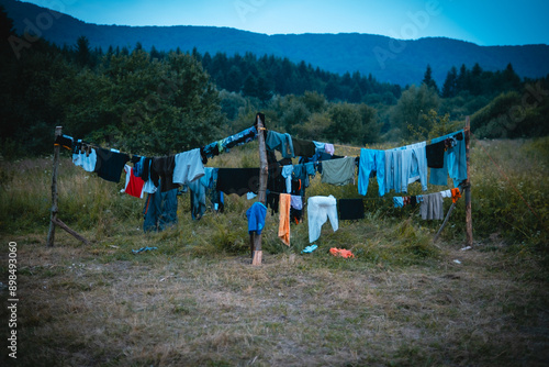 Clothes gently sway on an outdoor clothesline in the countryside at dusk, creating a peaceful scene