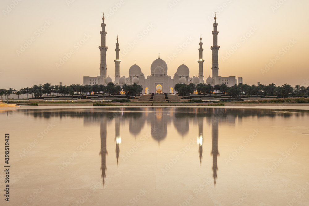 View of Grand Mosque in Abu Dhabi during very nice sunset. Beautifull warm colors on the sky.