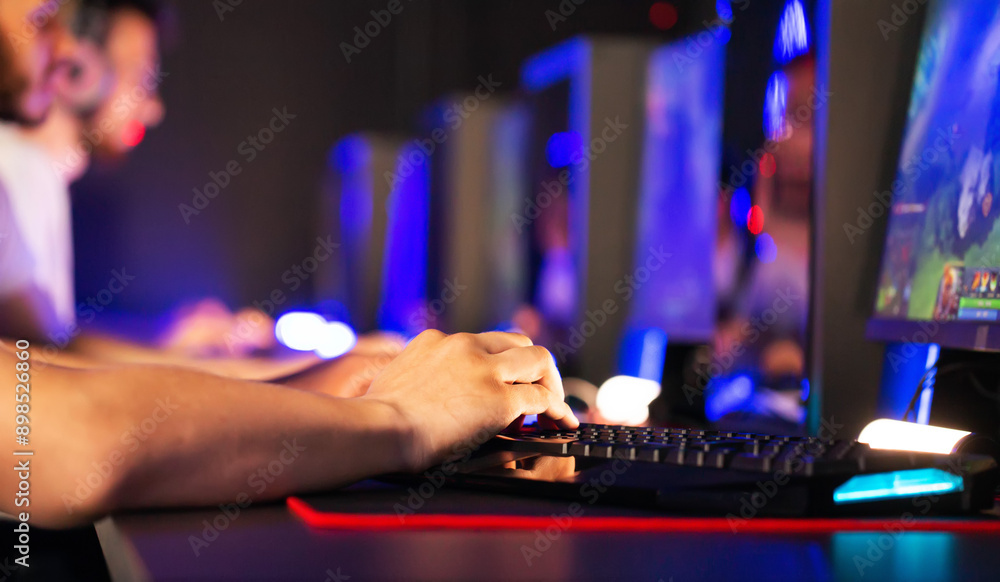Gamers play video game on PC at computer club, professional cyber sport tournament, gaming mouse RGB lighting keyboard on mat close up. E-sport championship. Multiplayer first-person shooter strategy Gamers play video game on PC at computer club, professional cyber sport tournament, gaming mouse RGB lighting keyboard on mat close up. E-sport championship. Multiplayer first-person shooter strategy