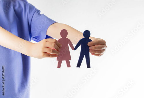 Tableau sur toile The girl holds figurines of her mother and father in her hands