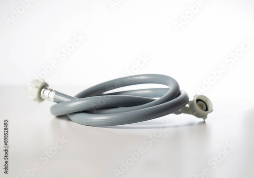 Gray twisted water hose from a washing machine on a white background, isolate, close-up