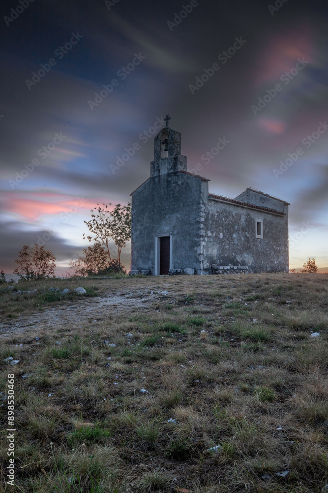Small historic church with a path leading to it. The church stands on a cliff in the sunrise and in a Mediterranean landscape. Historic mountain village of Bresc, Istria, Croatia Small historic church with a path leading to it. The church stands on a cliff in the sunrise and in a Mediterranean landscape. Historic mountain village of Bresc, Istria, Croatia