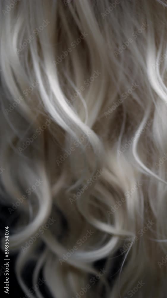 Flowing blond hair with curls fills the screen, creating texture. Ideal for film backgrounds or transitions. Studio lighting, beauty video shoot. Flowing blond hair with curls fills the screen, creating texture. Ideal for film backgrounds or transitions. Studio lighting, beauty video shoot.