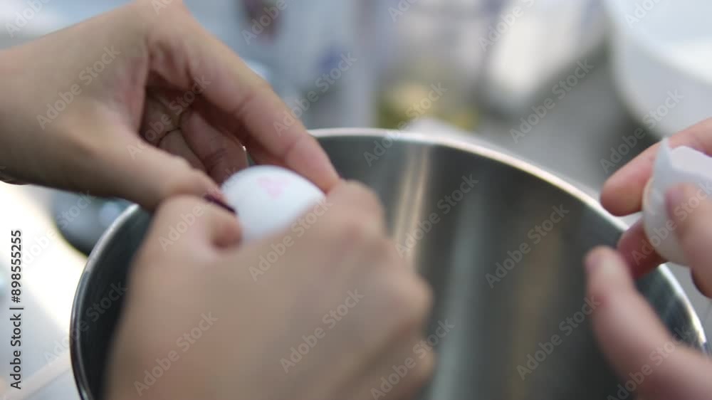 A female chef breaks eggs into a bowl to make cake batter, while butter and sugar are whipped together in a food processor. The view from the top. Break eggs. Master class two girls preparing pastries A female chef breaks eggs into a bowl to make cake batter, while butter and sugar are whipped together in a food processor. The view from the top. Break eggs. Master class two girls preparing pastries