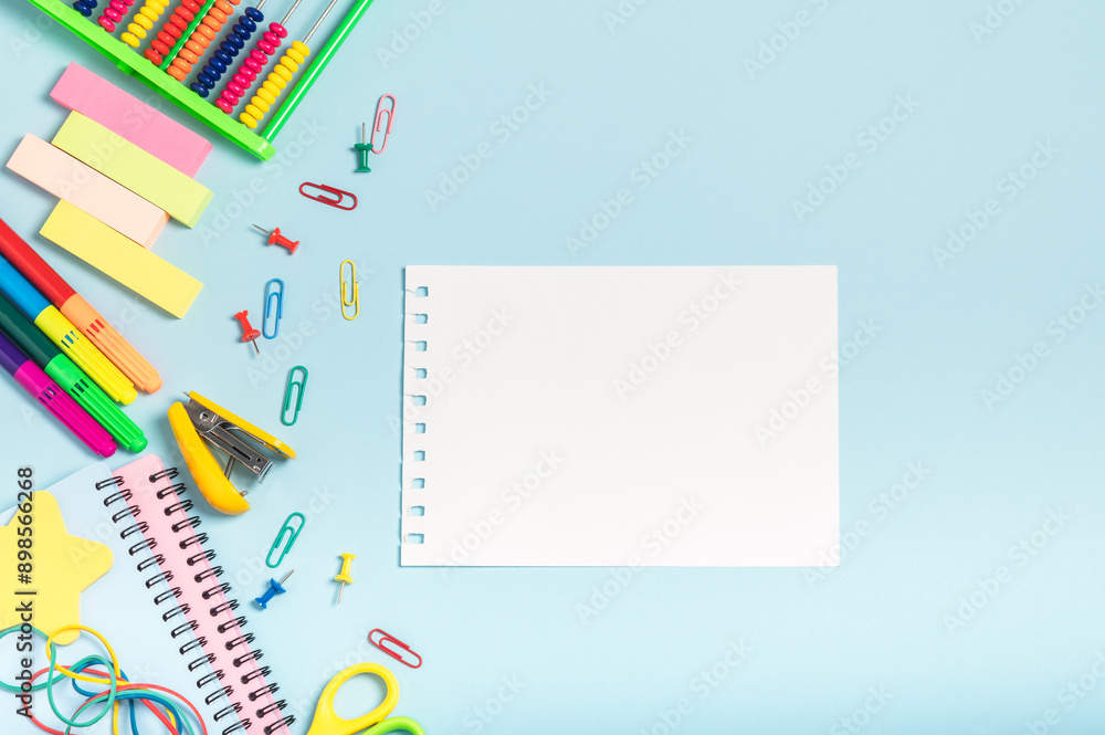 Back to school concept. School colored stationery on a blue background, blank album sheet. Workplace organization. Back to school concept. School colored stationery on a blue background, blank album sheet. Workplace organization.