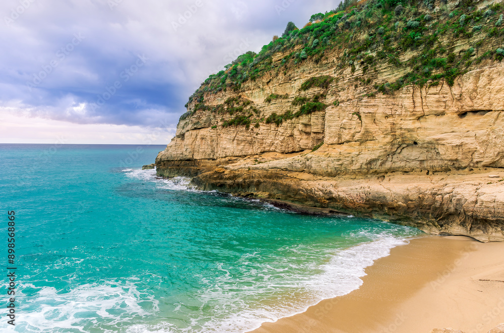 dramatic landscape of white sand beach with golden rocks and stones with beautiful rock cliff , sea surf and nice dramatic blue cloudy sky dramatic landscape of white sand beach with golden rocks and stones with beautiful rock cliff , sea surf and nice dramatic blue cloudy sky