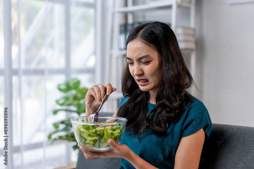 A woman is eating a salad with a fork A woman is eating a salad with a fork