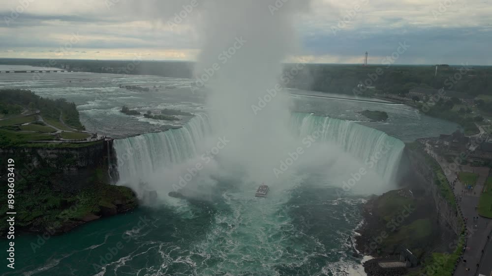 High-quality aerial cinematography of Niagara Falls captured in overcast weather. The clouds and mist create a dramatic and mystical atmosphere around the powerful waterfalls. Canada High-quality aerial cinematography of Niagara Falls captured in overcast weather. The clouds and mist create a dramatic and mystical atmosphere around the powerful waterfalls. Canada