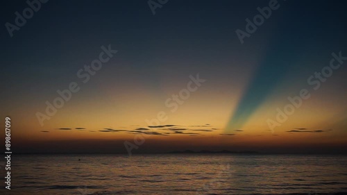 The peaceful sea with beautiful twilight sky in background. Golden sky with the horizontal line of seascape. Explosion of sunlight in the evening sky during the sunset
