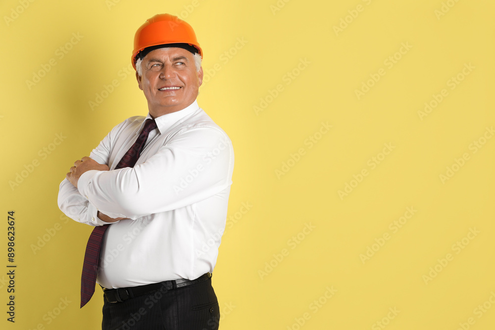 Engineer in hard hat on yellow background, space for text Engineer in hard hat on yellow background, space for text