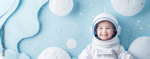 Happy cute smiling child in astronaut costume on the pastel blue background.