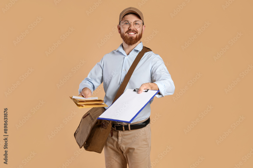 Happy young postman with leather bag delivering letters on brown background Happy young postman with leather bag delivering letters on brown background