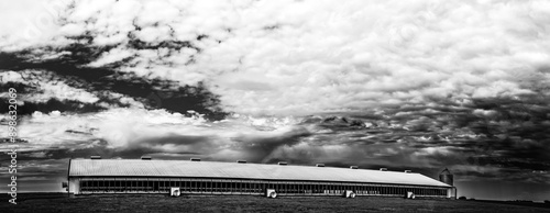Valokuva Hog animal confinement barn in a rural setting with cloudy skies