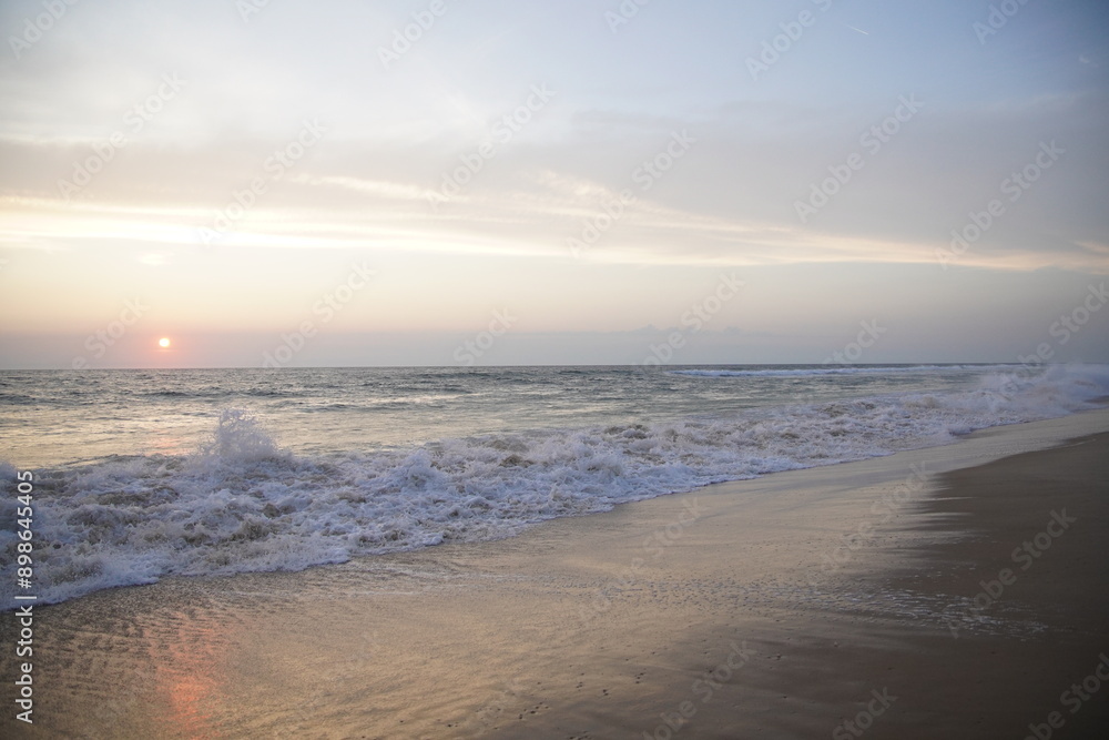 Atardecer en una playa vacia con grandes olas y rojo atardecer Atardecer en una playa vacia con grandes olas y rojo atardecer