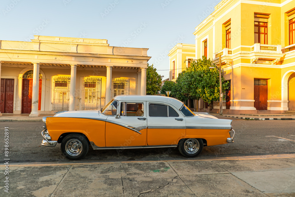 Fototapeta premium beautiful old classic american yellow and white car in cienfuegos old town cuba streets