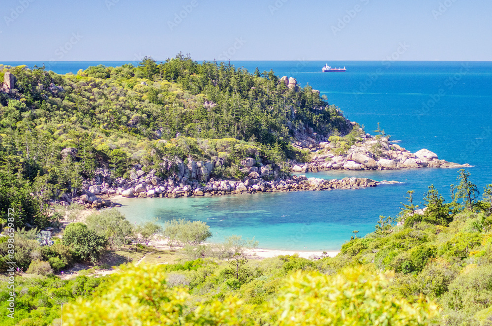 Picturesque golden sandy Arthur Beach with granite boulders and turquoise water on Magnetic Island, Queensland, Australia. The island is a holiday destination 8 km offshore of Townsville.