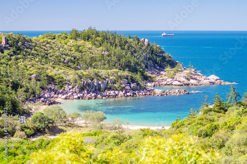 Obraz na płótnie Picturesque golden sandy Arthur Beach with granite boulders and turquoise water on Magnetic Island, Queensland, Australia. The island is a holiday destination 8 km offshore of Townsville. w salonie