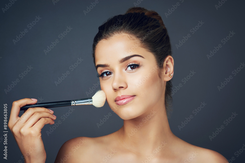 Fototapeta premium Makeup, portrait and woman in studio with brush for glow, natural cosmetics or shine on gray background. Aesthetic, salon and female model with equipment for facial powder, foundation or beauty