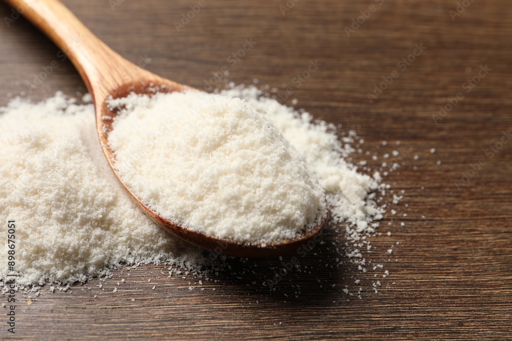 Coconut flour in spoon on wooden table, closeup Coconut flour in spoon on wooden table, closeup