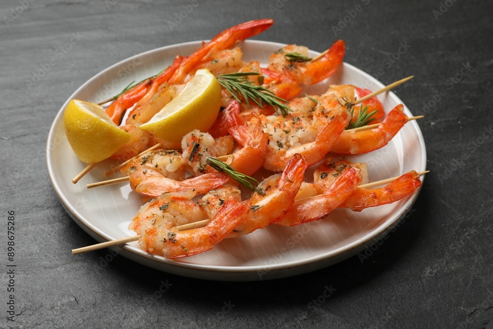 Skewers with delicious grilled shrimps served on black table, closeup Skewers with delicious grilled shrimps served on black table, closeup