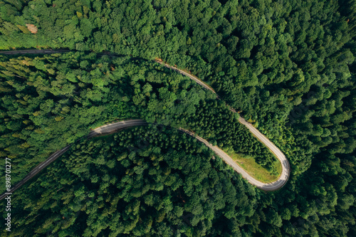 Aerial view of the road passing through the mountain and green forest. Curve asphalt road on mountain. 