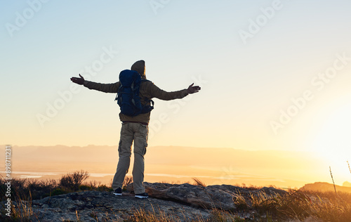 Obraz na płótnie Mountain, sunset sky and person with hiking achievement, freedom or trekking vacation with backpack. Heaven, prayer and hiker with arms raised on cliff for outdoor adventure holiday success in nature w salonie