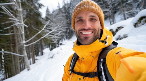 This image features a smiling man in a bright yellow jacket standing in the middle of a snowy forest, enjoying a moment of contentment and the beauty of the winter landscape.