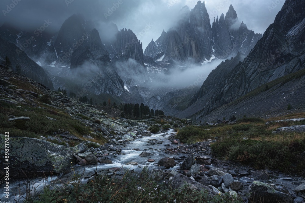 A serene stream flows through a rugged mountain valley with rocky terrain and lush greenery A serene stream flows through a rugged mountain valley with rocky terrain and lush greenery