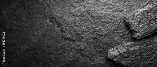  A tight shot of a rock, textured with dark gray paint, bears a rusted metal ring atop