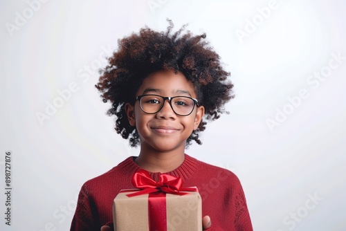 Smiling Child Holding Gift Box with Red Ribbon photo