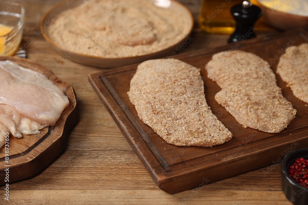 Making schnitzels. Raw meat and other ingredients on wooden table, closeup Making schnitzels. Raw meat and other ingredients on wooden table, closeup