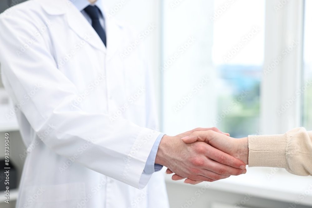 Doctor shaking hands with patient in clinic, closeup Doctor shaking hands with patient in clinic, closeup