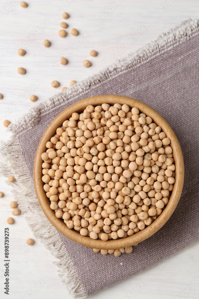 Dried peas in bowl on light wooden table, top view Dried peas in bowl on light wooden table, top view