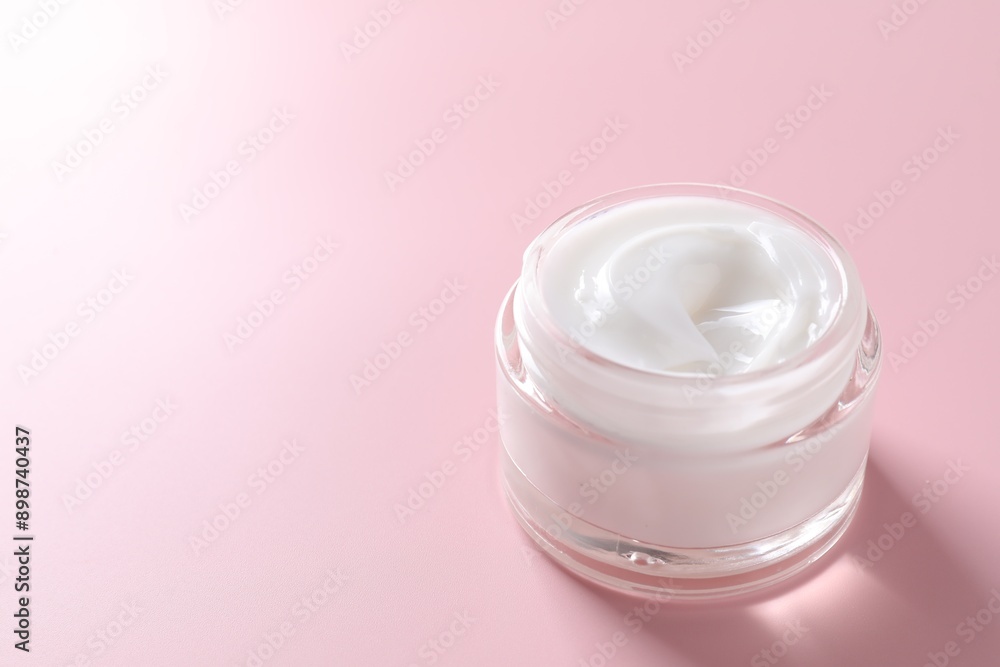 Face cream in jar on pink background, closeup. Space for text Face cream in jar on pink background, closeup. Space for text