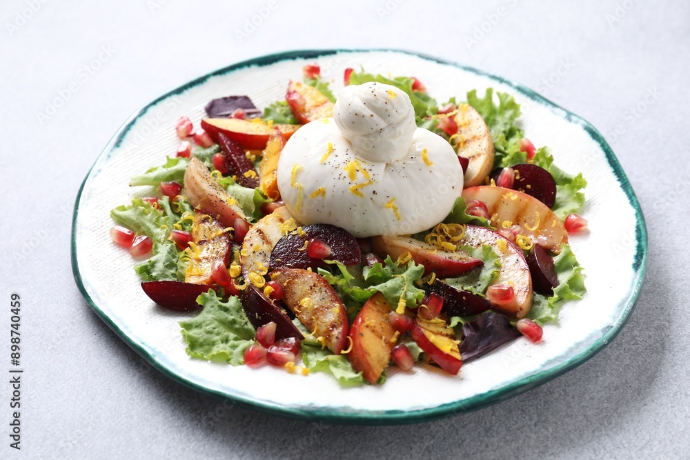 Plate with fresh burrata salad on grey table, closeup Plate with fresh burrata salad on grey table, closeup