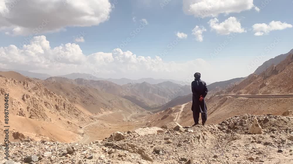 Muslim man stand thoughtful on viewpoint enjoy scenic view in Afghanistan. Salang pass serpentine road scenery. Primary mountain pass connecting northern Afghanistan with Parwan Province Muslim man stand thoughtful on viewpoint enjoy scenic view in Afghanistan. Salang pass serpentine road scenery. Primary mountain pass connecting northern Afghanistan with Parwan Province