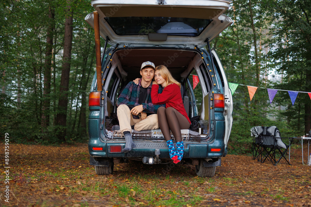 Young Couple Relaxing Inside Van Amidst Dense Forest Young Couple Relaxing Inside Van Amidst Dense Forest
