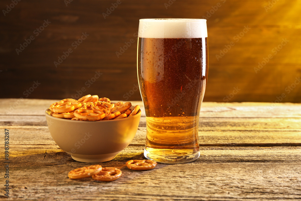 Glass of beer and pretzel crackers on wooden table Glass of beer and pretzel crackers on wooden table