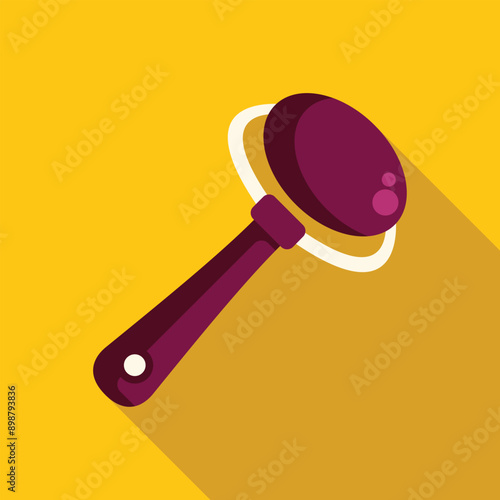 Baby beanbag rattle toy lying on a yellow background with a long shadow