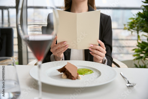Wallpaper Mural Cropped photo of woman in black suit holding bill while sitting in the restaurant Torontodigital.ca