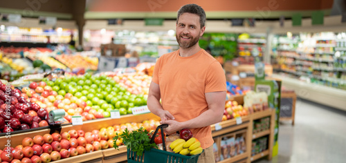Bild auf Leinwand Handsome man hold shopping cart full of groceries