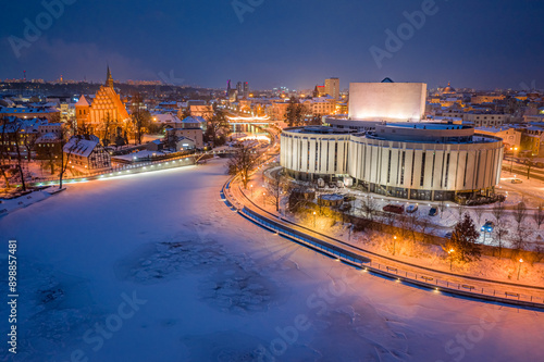 Opera building by frozen Brda River after dark in Bydgoszcz