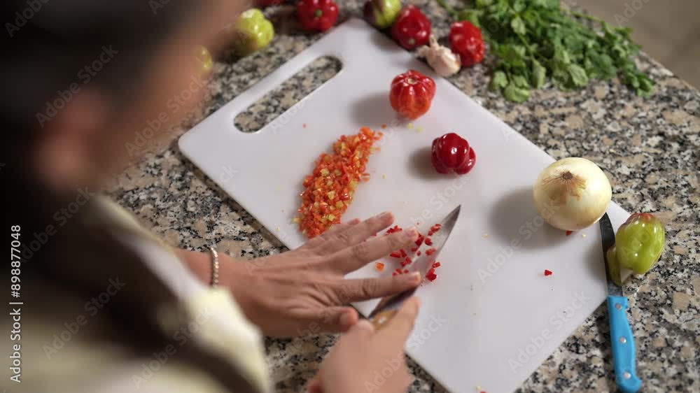 Mujer preparando y cortando alimentos frescos de varios colores en su cocina