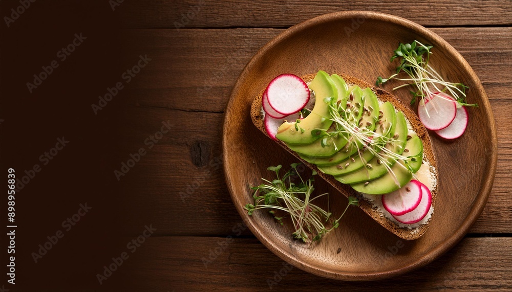 Flat lay of a plate of whole grain toast topped with avocado, radishes, and microgreens, arr Flat lay of a plate of whole grain toast topped with avocado, radishes, and microgreens, arr