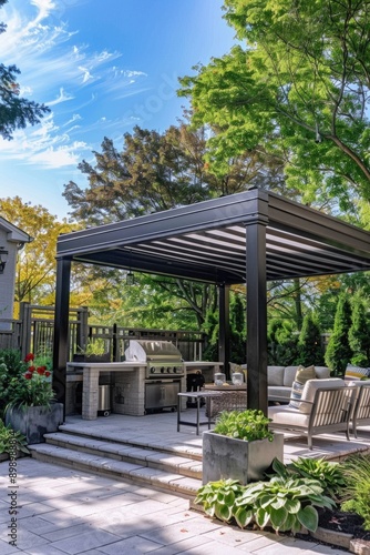 Outdoor living space with table and chairs around a grill, suitable for family gatherings or casual meals © Fotograf