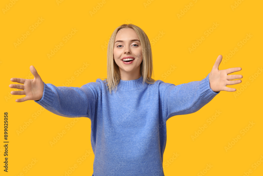Young woman opening arms for hug on yellow background Young woman opening arms for hug on yellow background
