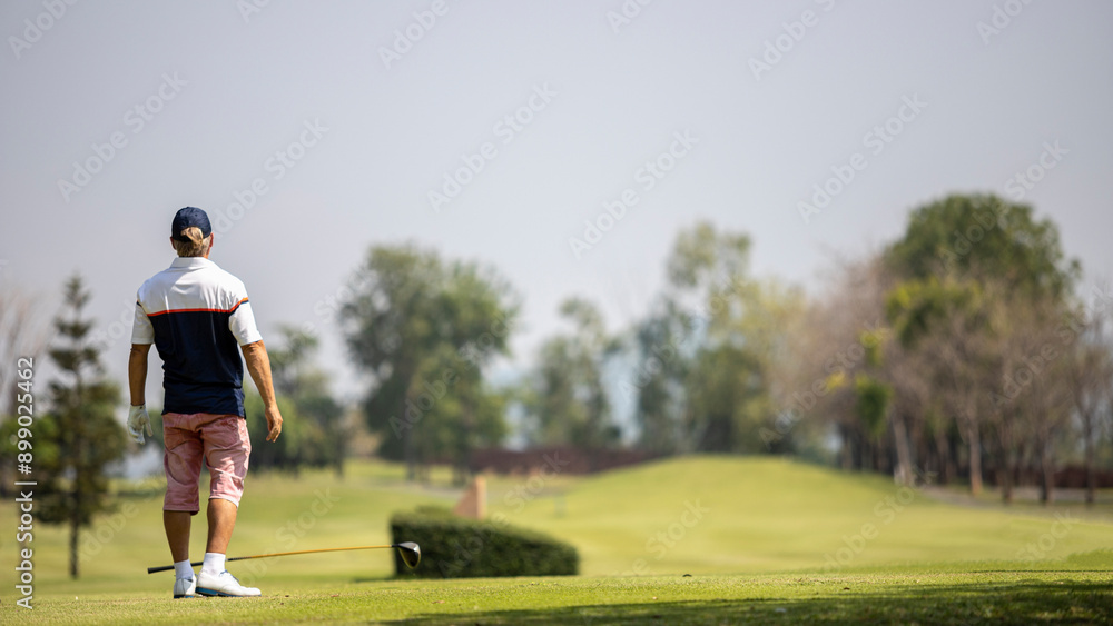 A golfer looks disappointed at his shot. A golfer looks disappointed at his shot.