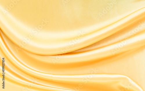 yellow gold satin texture that is white silver fabric luxurious shiny that is abstract silk cloth background with patterns soft waves blur beautiful. photo