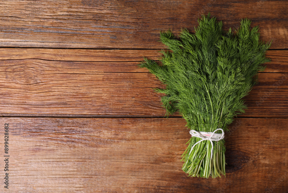 Bunch of fresh green dill on wooden table, top view. Space for text Bunch of fresh green dill on wooden table, top view. Space for text