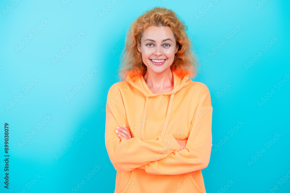 Redhead Caucasian woman or girl in casual stylish hoodie looking trendy isolated on blue Redhead Caucasian woman or girl in casual stylish hoodie looking trendy isolated on blue